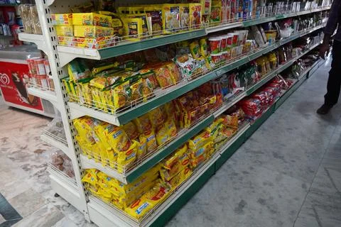Several packets of packaged noodles kept on shelf for sale. Maggi instant noo Stock Photos