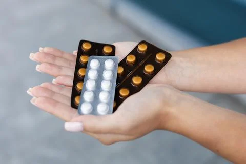 Several packs of pills held by white female nurses' hands outside Stock Photos
