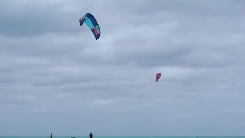 Several people are going to kitesurf on a paradisiac beach during a cloudy Vídeo Stock 153643155