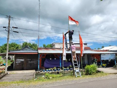 Several people climbed onto a pole to raise the flag of the of Indonesia Stock Photos