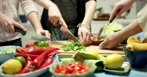 Several people preparing vegetables for a taco dinner Stock Footage 61535408