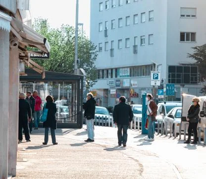 Several people standing in a queue of a shop holding a distance between them  Stock Photos