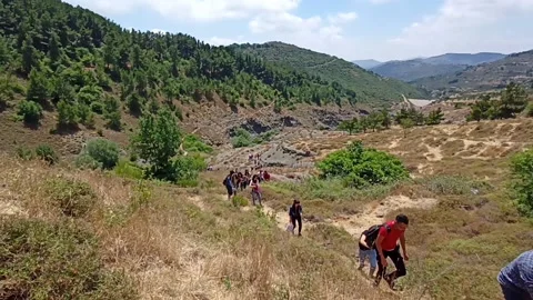 Several people walking in a mountain pass and climbing to the top Stock Footage 194376534