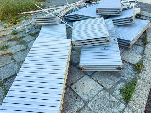 Several pieces of construction materials lay stacked on the pavement near a b Stock Photos