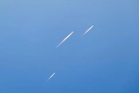 Several planes fly in the sky at the same time with trail. Stock Photos