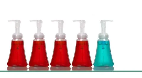 Several plastic hand soap bottles on a glass shelf Stock Photos
