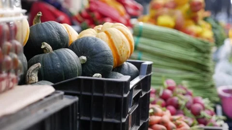 Several pumpkins and mixed vegetables arranged on a local market stall counter f Stock Footage 341407935