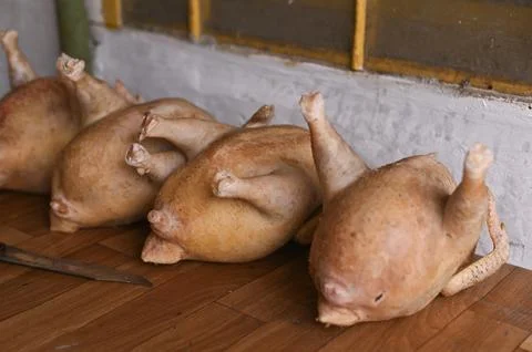 Several raw chickens arranged on a rustic wooden table, ready for preparati.. Stock Photos