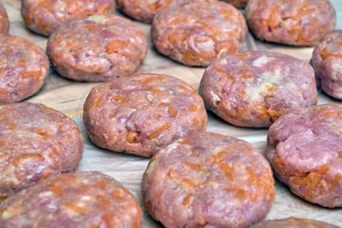 Several raw cutlets of beef and pork lie on a wooden Board. Stock Photos