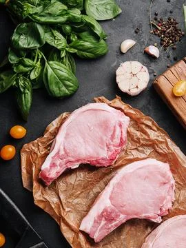 Several raw pork steaks on baking paper Stock Photos