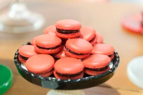 Several red macaroons on a black ceramic tray. Stock Photos