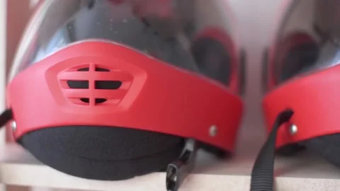 Several red protective helmets with plastic visor on the shelf Stock Footage 91744023