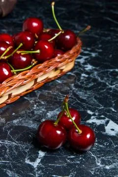 Several red sweet cherries on the table. Fresh organic cherry in yellow woode Stock Photos