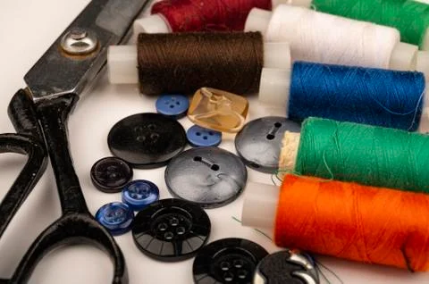 Several reels of multicolored sewing thread, multicolored buttons of differen Stock Photos