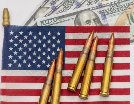 Several rifle bullets placed on a small United States flag with hundred dolla Foto stock