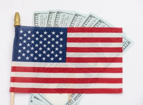 Several rifle bullets placed on a small United States flag with hundred dolla Stock Photos