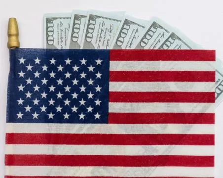 Several rifle bullets placed on a small United States flag with hundred dolla Foto stock