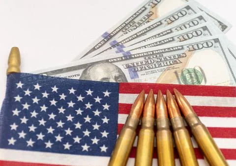 Several rifle bullets placed on a small United States flag with hundred dolla Foto stock