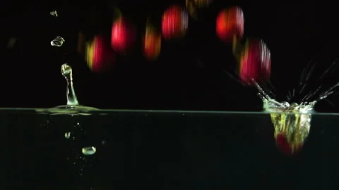 Several ripe red strawberries fall beautifully into the water with bubbles and s Stock-Footage 116018645