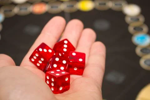 Several rolling red dice fall on a table with boardgame. Gameplay moments Foto stock