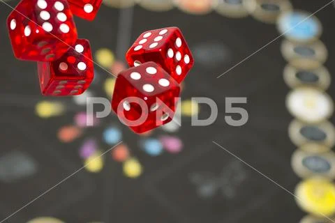 Several rolling red dice fall on a table with boardgame. Gameplay moments Stock Photos