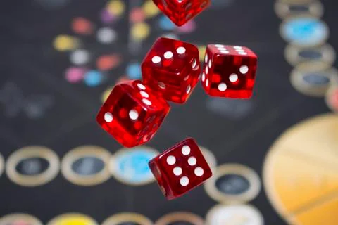 Several rolling red dice fall on a table with boardgame. Gameplay moments Foto stock