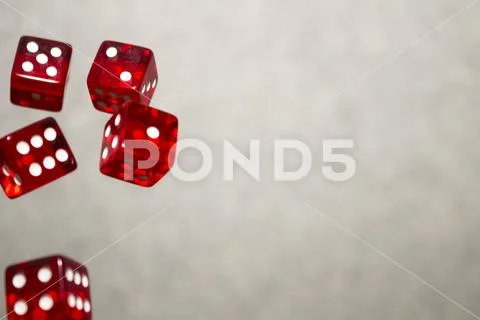 Several rolling red dice fall on a table with boardgame. Gameplay moments Stock Photos