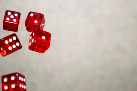 Several rolling red dice fall on a table with boardgame. Gameplay moments Stock Photos