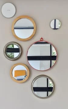 Several round mirrors in a different setting on the wall in the room Stock Photos