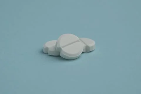 Several round white tablets isolated on a blue background. Top view, flat l.. Stock Photos