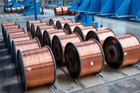 Several rows of finished coils with copper wire in production. Stock Photos