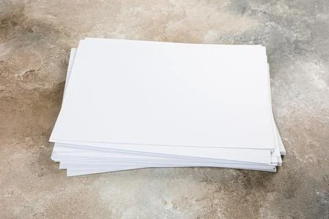 Several sheets of paper in a pile of a4 a5 business card on a grunge table. Stockfoto's