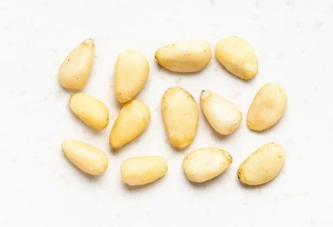 Several shelled pine nuts close up on gray Stock Photos