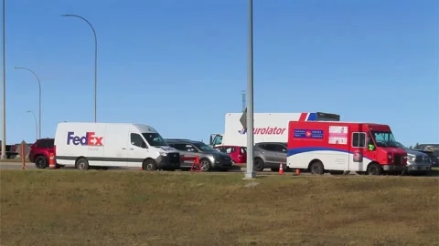 Several Shipping trucks from FedEx, Canada Post and Purolator delivery trucks Stock Footage 219983099