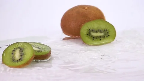A Several Slices of Kiwi are Falling on the Table. Stock Footage 76993073