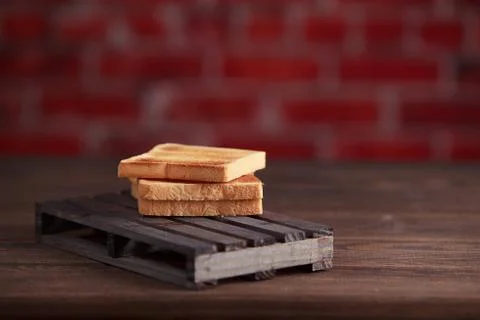 Several slices of toasted bread toasts on a wooden dark background. Stock Photos