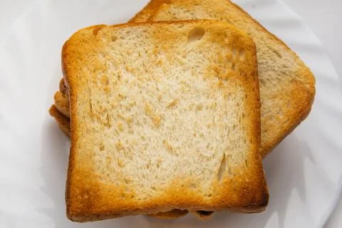 Several slices of white bread are prepared for breakfast. Put crispy toasts o Stock Photos