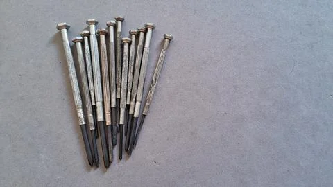 Several small metal precision screwdrivers arranged neatly on gray surface Stock Photos