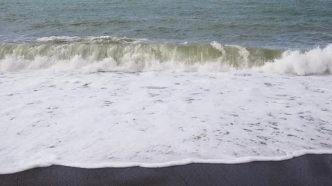 Several small waves roll on a sandy beach Stock Footage 82657058
