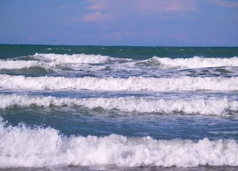 Several splashing tide waves reaching to shore Stock Photos
