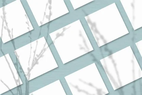 Several square sheets of white textured paper against a blue grey wall backgr Stock Illustration