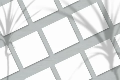 Several square sheets of white textured paper against a grey wall background. Stock Illustration