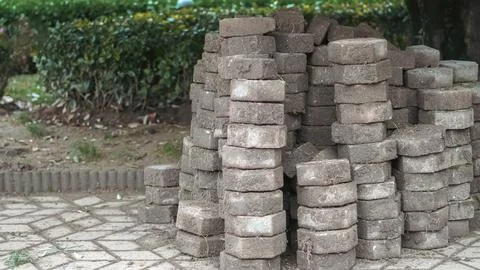 Several stacks of weathered, octagonal paving stones covered in soil and drie Stock Photos