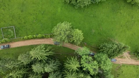 Several SUVs are driving along a mountain road along a dirt road. Aerial view. Video stock 169755277