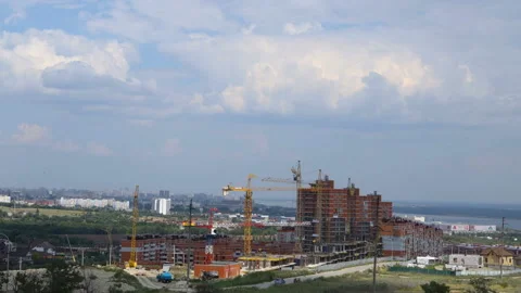 Several tower cranes against the clouds build a multi-storey building and move c Stock Footage 113339081