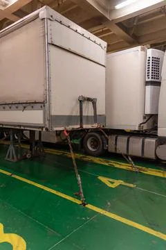 Several trailers moored with chains in the hold of a ship Stock Photos