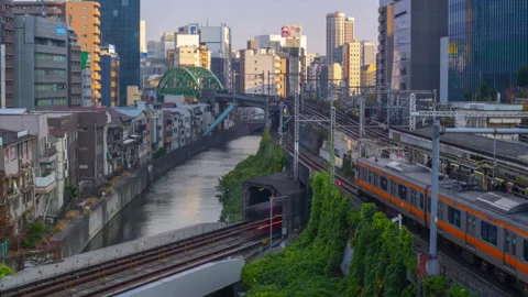 Several trains come and go at the Ochanomizu Station crossing over Kanda River Stock Footage 335433401