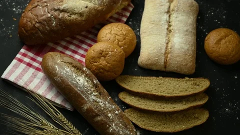 Several types bread with wheat spins on black table Stock Footage 128044354
