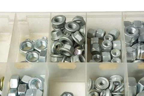 Several types of nuts in open compartments of storage box on table in works.. Stock Photos