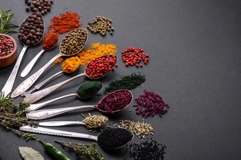 Several types of spices in metal spoons paprika, tomatoes, curry, beets, cumi Stock Photos